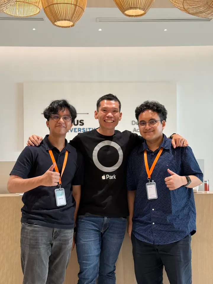 Adrian with two others at the Academy, all wearing lanyards