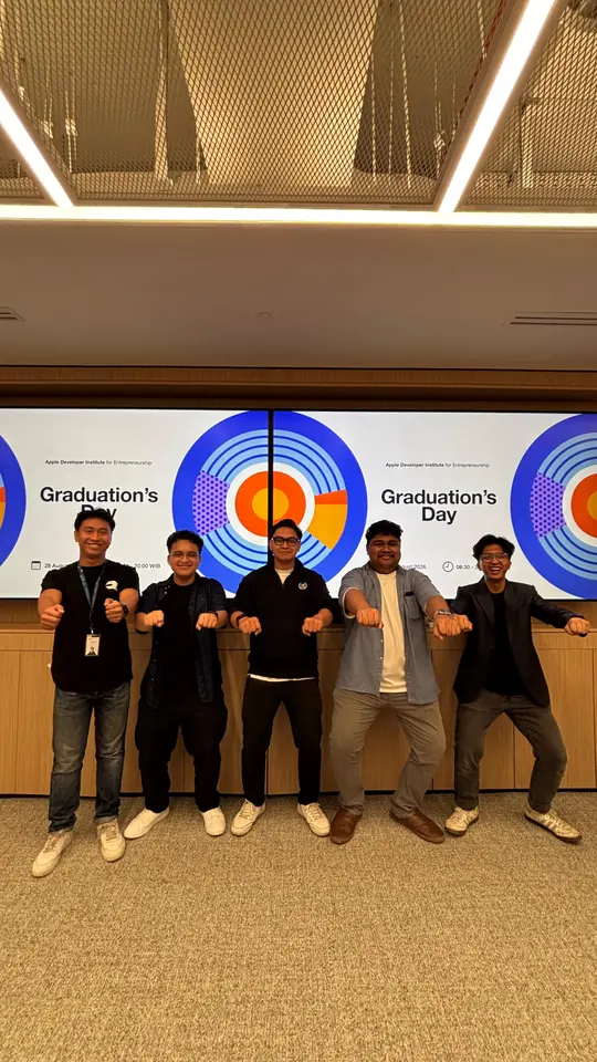 Adrian, his teammates and their Institute mentor, in the middle, striking a pose in front of a Graduation’s Day screen