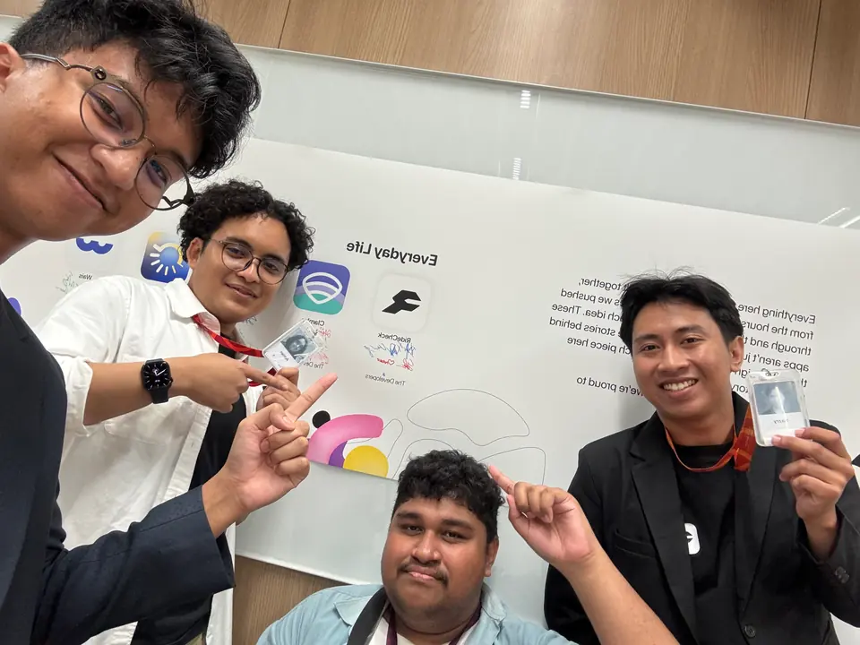The team pulling faces in front of a wall of app icons