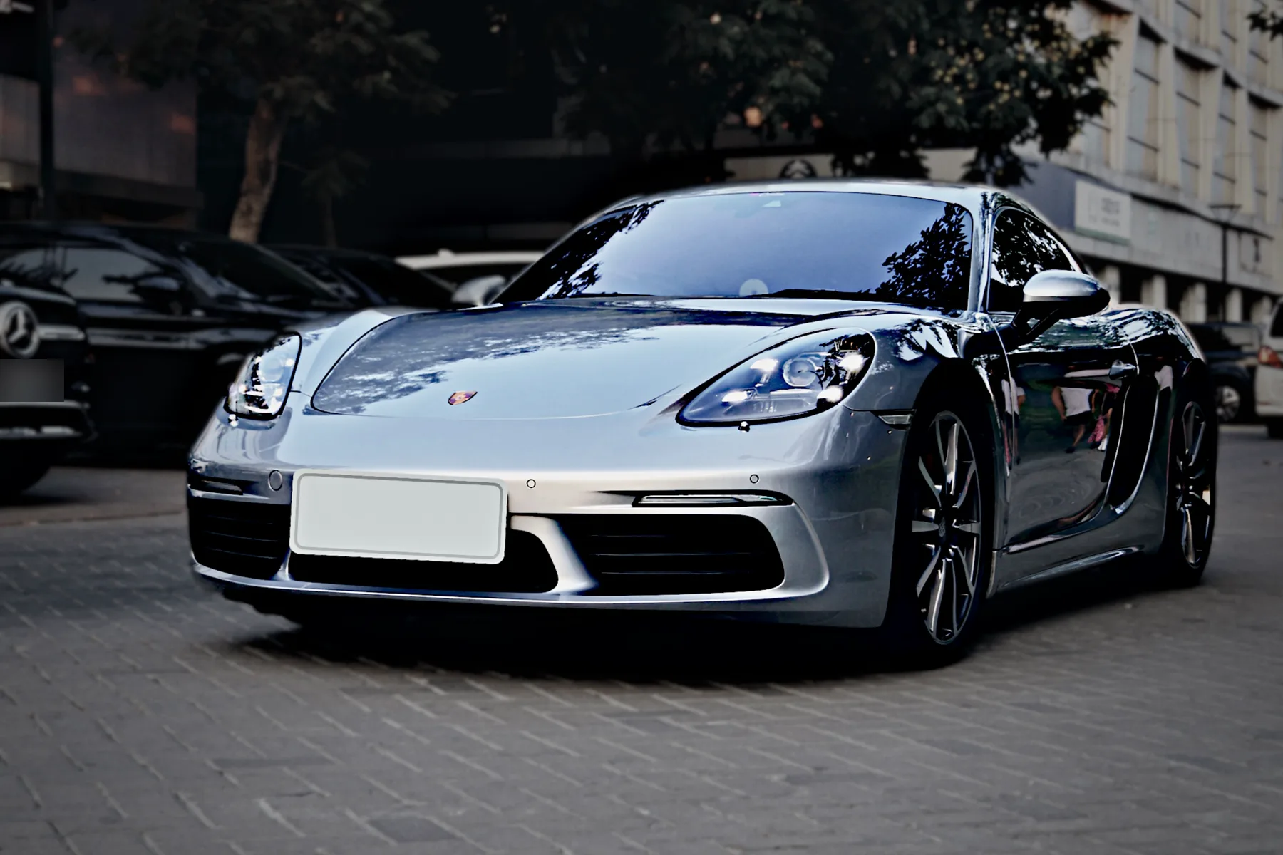 After: the same Cayman with the scene darkened around it, the body bright and glossy, and the plate covered